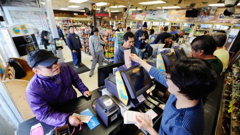 Customers wait in line Thursday to buy their Mega Millions tickets at a liquor store in Hawthorne, California.