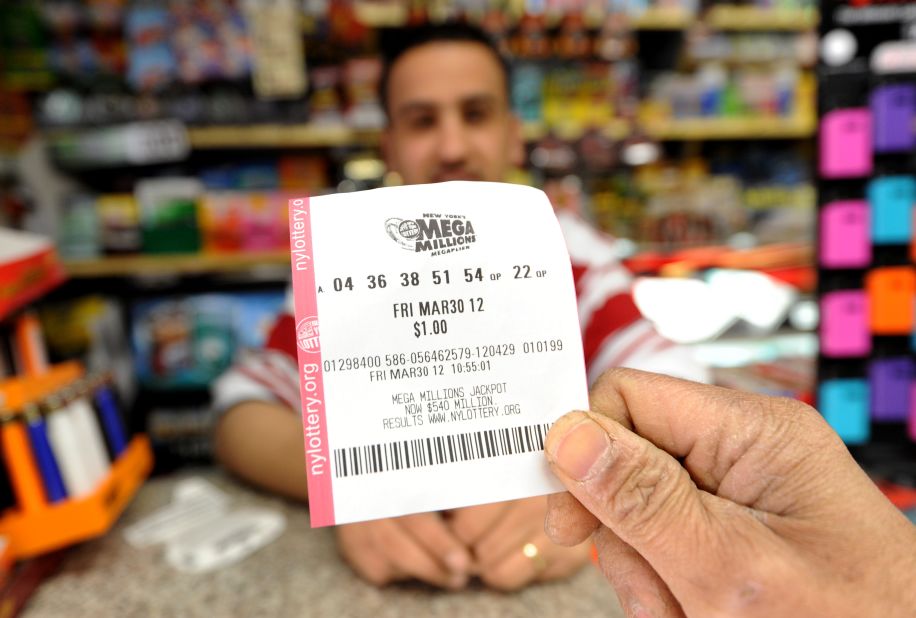 A man shows his Mega Millions ticket in front of clerk Abdulwali Mohamed Osaim at a convenience store on Manhattan's East Side.
