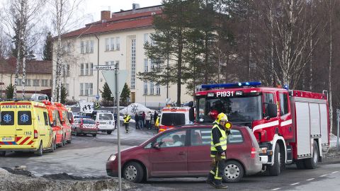 Ambulances, police cars and fire department vehicles are parked outside the school in the Tampere area on Friday.