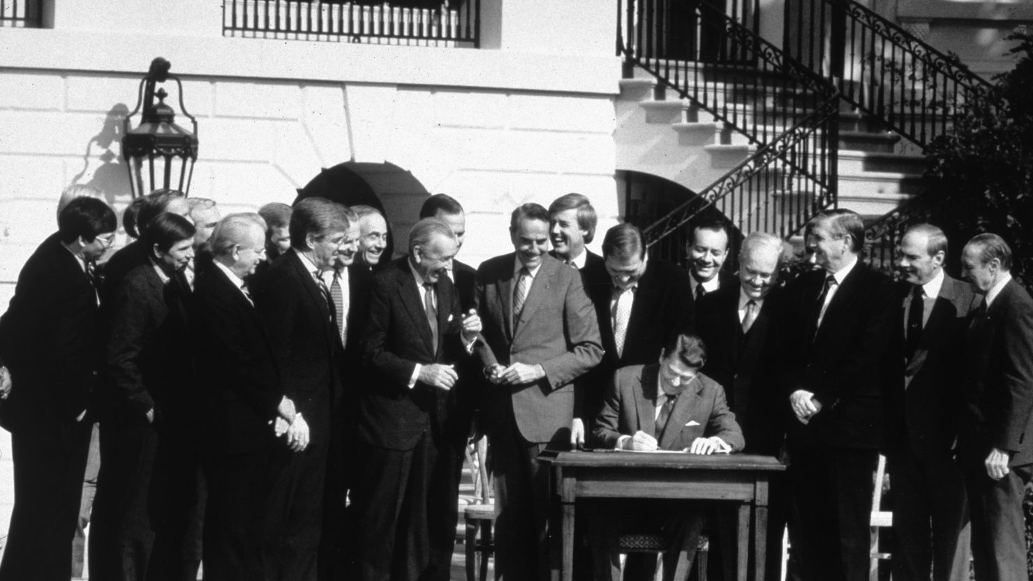 President Ronald Reagan signs the Tax Reform Act in October 1986, with congressional leaders joining in the ceremony.       
