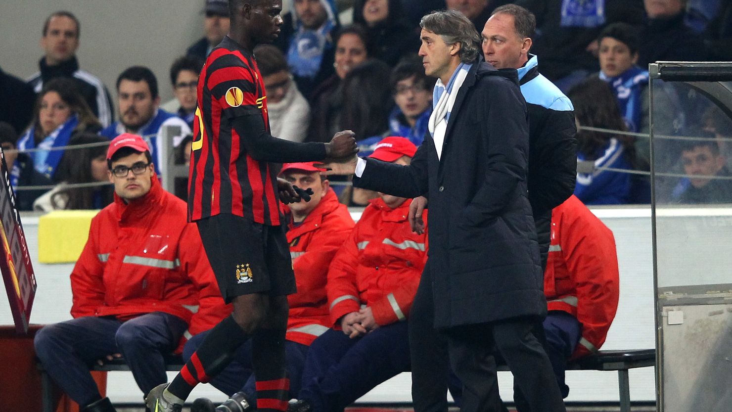 Mario Balotelli shakes hands with manager Roberto Mancini after being substituted in the Europa League tie at Porto.