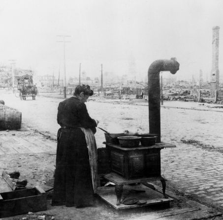 A woman cooks a meal in the street after the San Francisco earthquake on January 1, 1906.