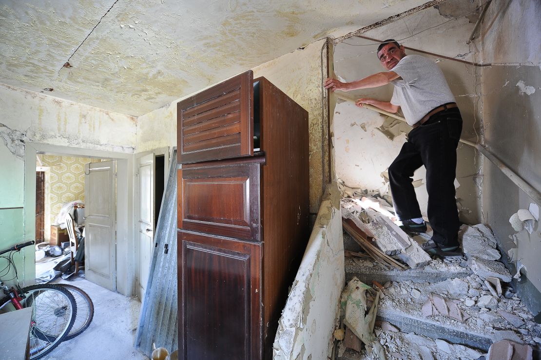 A L'Aquila resident in his damaged home.