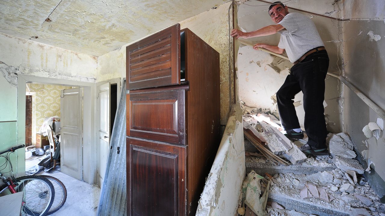 A L'Aquila resident in his damaged home.