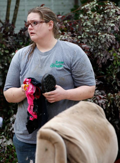 A woman holds a few personal items after a tornado destroyed her home in Arlington. 