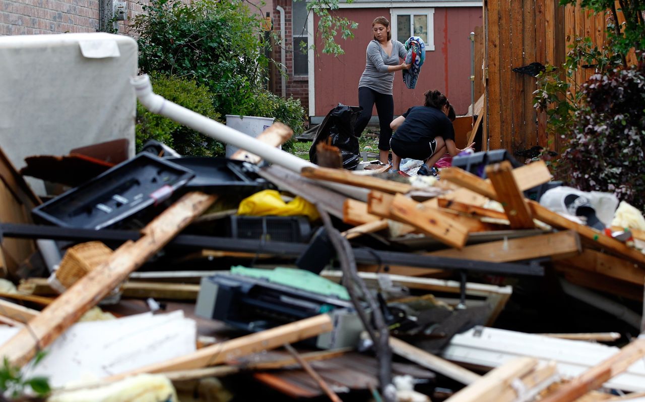 Residents search for personal belongings after a tornado destroyed their home in Arlington.