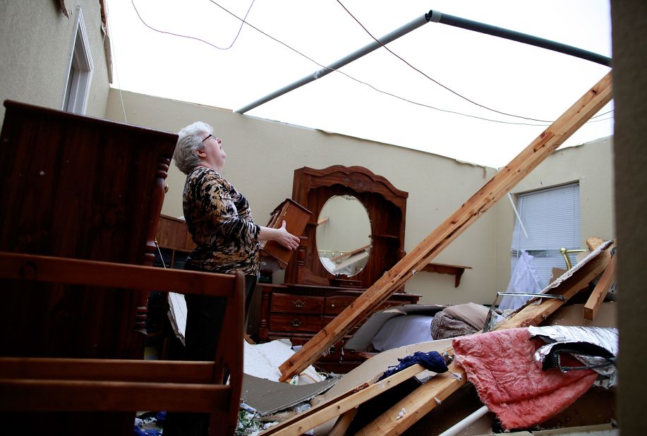 Patricia Daugherty searches through her belongings after her home was destroyed.