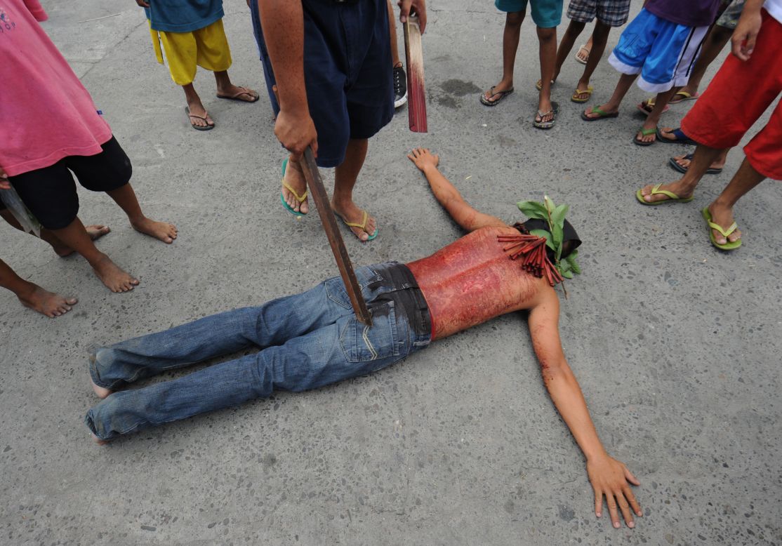 A penitent lies on the ground on the eve of the Good Friday re-enactments of the crucifixion of Jesus Christ in San Fernando City, north of Manila, Philippines. Despite the church's advice to shun the practice, devout Filipinos have themselves nailed to crosses as Asia's bastion of Catholicism marks Good Friday.