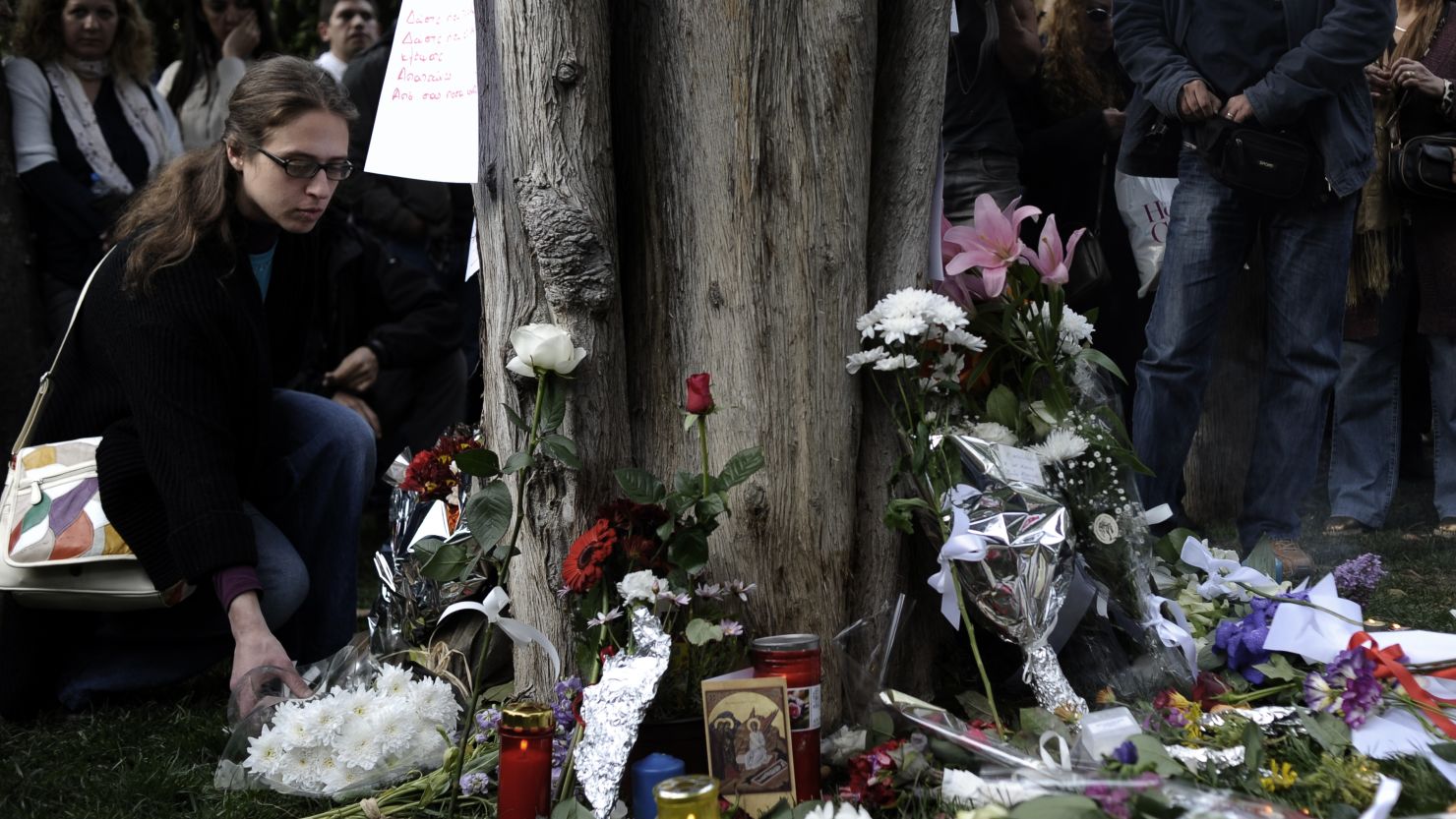 People lay flowers at the site where an elderly man shot himself at Syntagma square in Athens on April 4, 2012. 