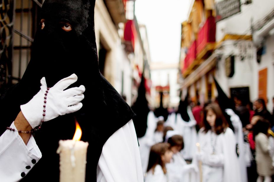 A penitent of the Perdon brotherhood walks during a Holy Week procession in Cordoba, Spain.