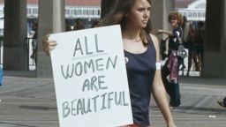 <strong>All women are beautiful: A protest against the Miss America Pageant at Atlantic City, New Jersey, September 6,1969:</strong> A woman walks past with a sign reading 'All women are beautiful'.