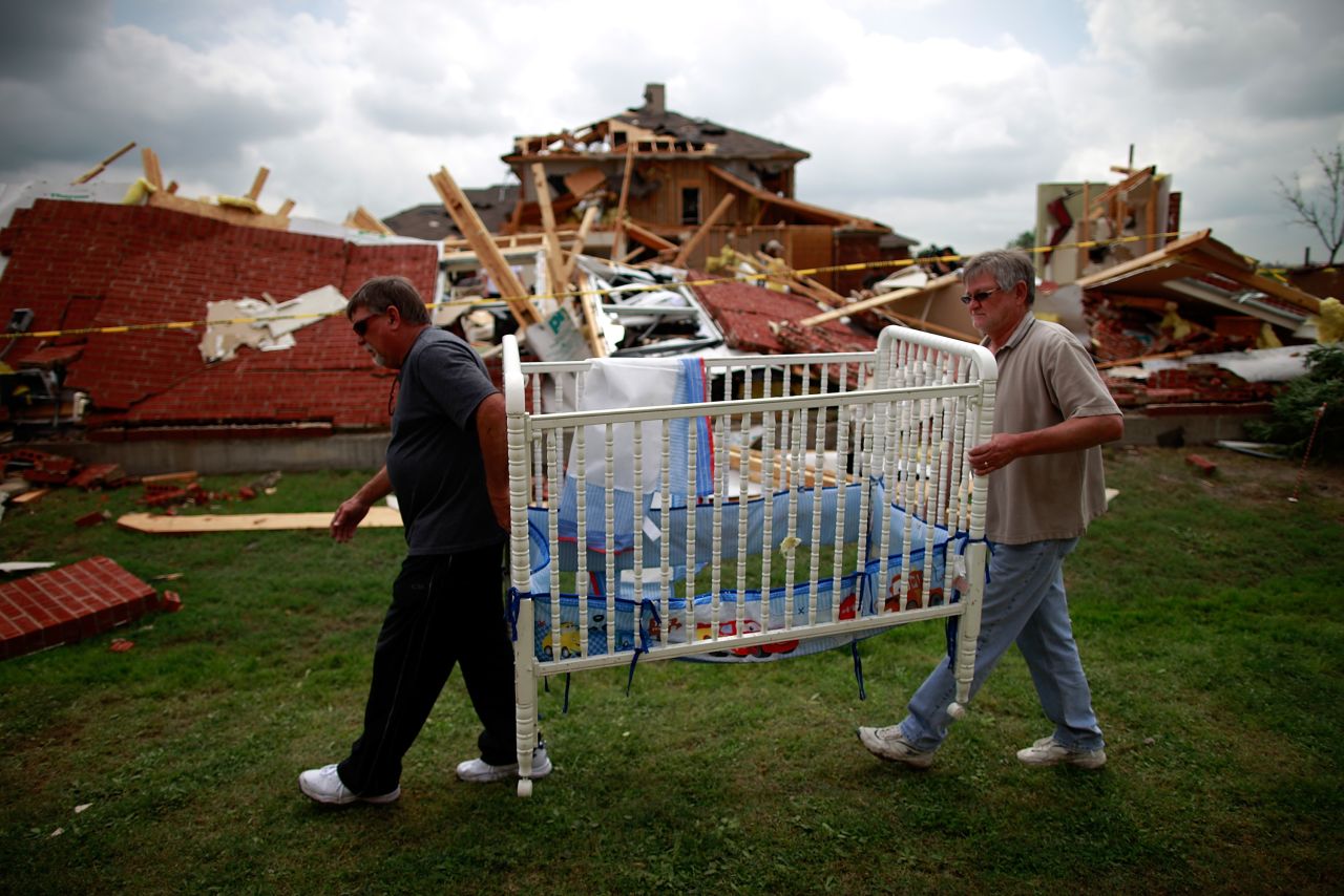 Mike Enochs, left, and Gary Enochs salvage a baby crib from Mike Enochs' destroyed home. There are no reports of deaths so far, according to the mayors of Dallas and Arlington.