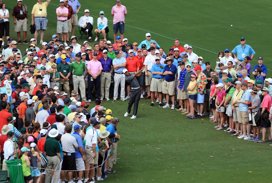 Tiger Woods hits a shot on the ninth hole in front of a gallery of patrons during the first round of the 2012 Masters Tournament.
