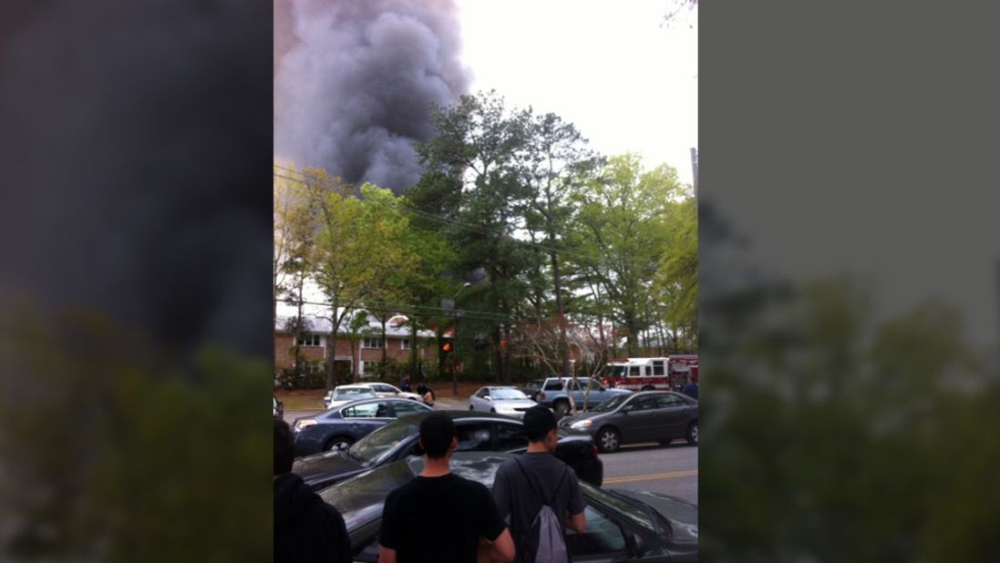 Spectators watch as smoke billows from an apartment building in Virginia Beach.