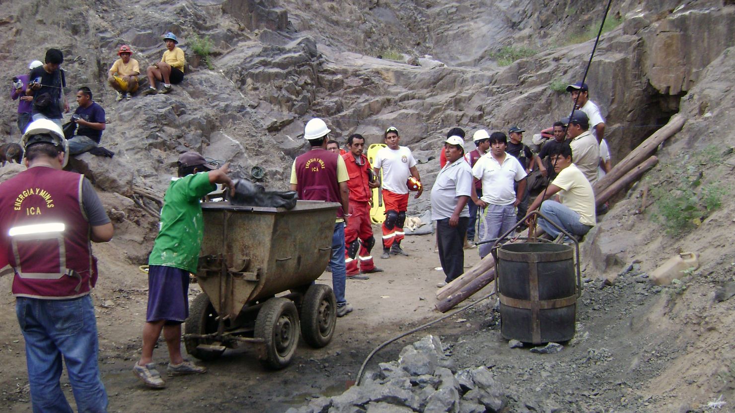 Workers walk toward the entrance of a mine east of Ica, Peru, on Friday in an attempt to rescue nine trapped miners.