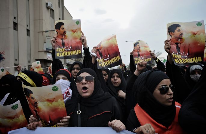 Bahraini Shiite demonstrators hold posters of jailed activist Abdulhadi al-Khawaja during a protest calling for his release in the village of Jidhafs, west of Manama, on April 6, 2012. 