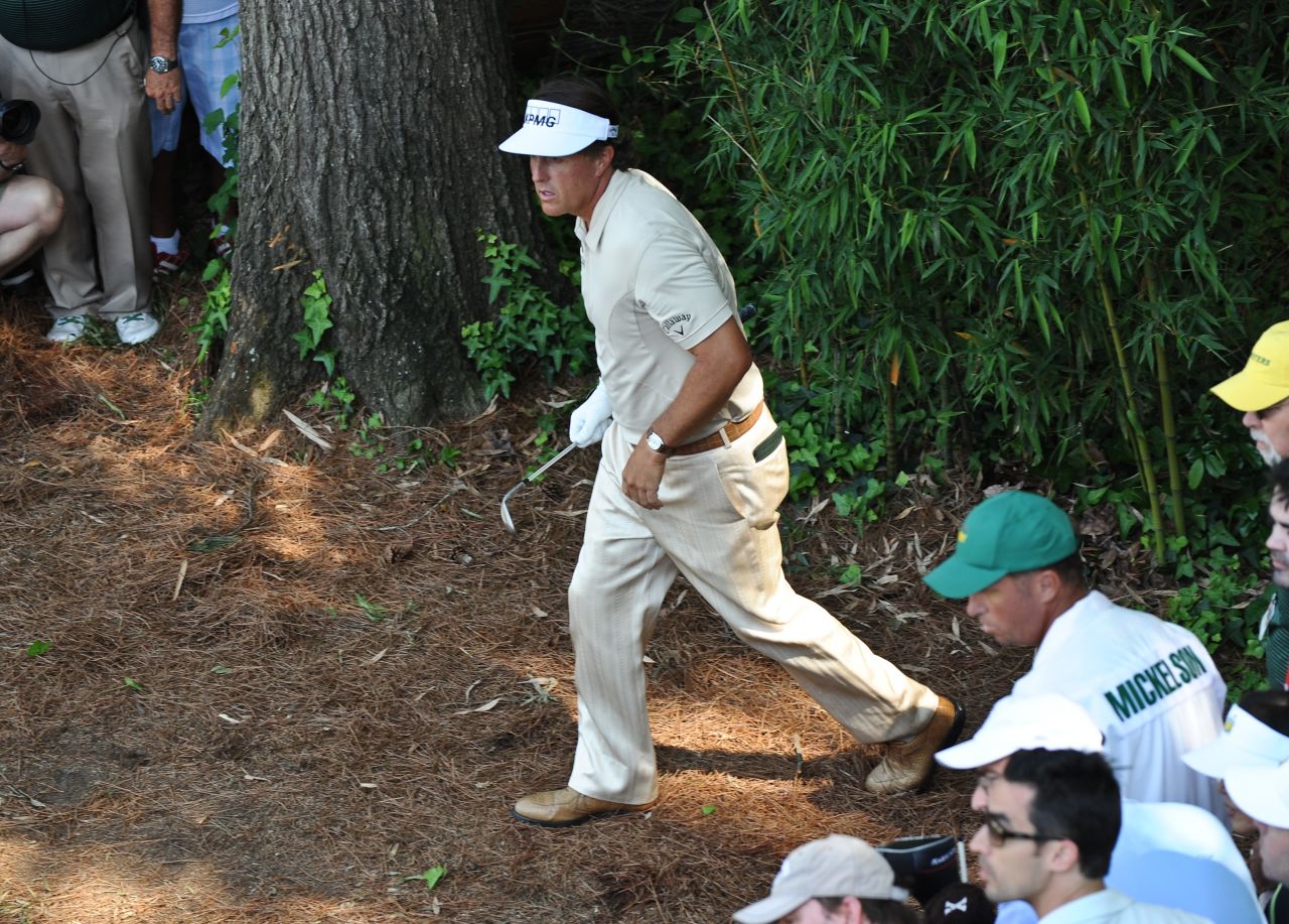 Phil Mickelson watches his shot from the rough at the fourth on the way to a triple bogey.