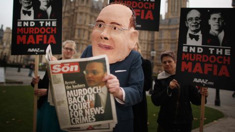  A protester poses as James Murdoch reading a spoof newspaper following allegations of hacking at News International in 2011