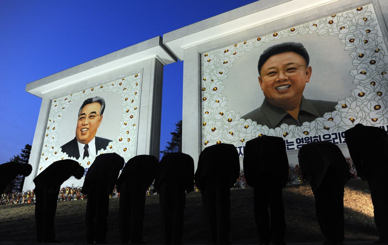 North Korean citizens bow before the portraits of the founding father Kim Il-Sung, left, and his son Kim Jong-Il, in Pyongyang, North Korea on Monday, April 9, 2012. April 15 marked the 100-year anniversary of the founder's birth and journalists were allowed inside the country.
