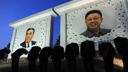 North Korean citizens bow before the portraits of the founding father Kim Il-Sung, left, and his son Kim Jong-Il, in Pyongyang, North Korea on Monday, April 9, 2012. April 15 marked the 100-year anniversary of the founder's birth and journalists were allowed inside the country.
