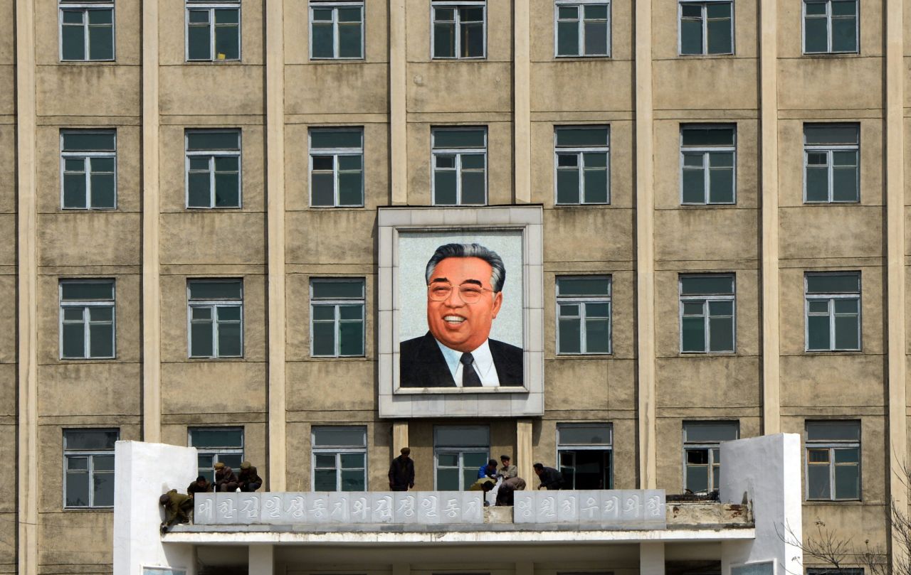 A building adorned with a huge portrait of the late president Kim Il-Sung is cleaned by workers in Pyongyang.