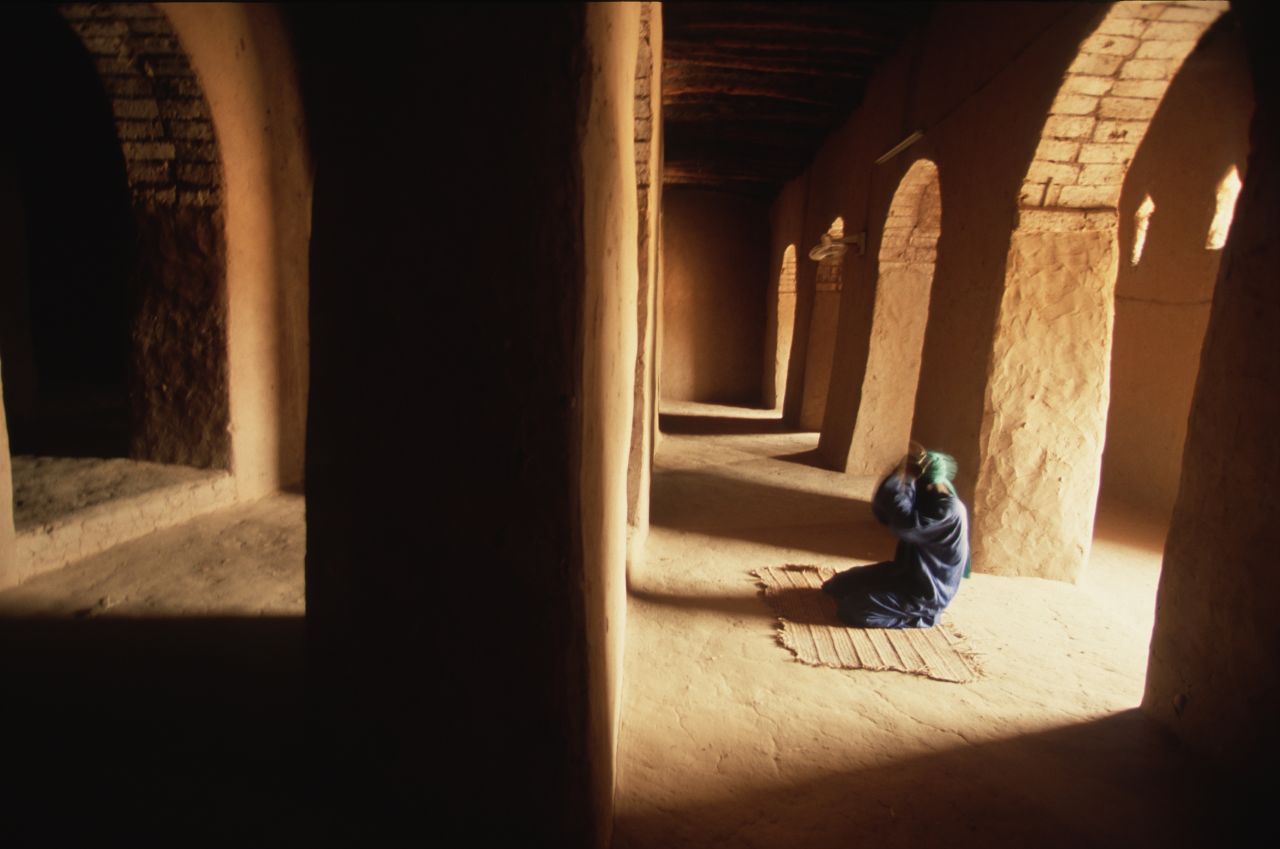 A man prays inside the Sankore mosque in Timbuktu. Part of the madrasah was commissioned by Mansa Musa I. 
