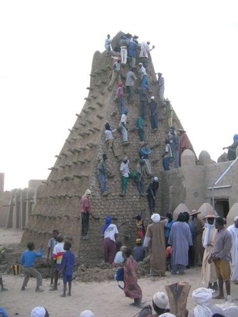 People climb the mosque. The buildings are important sources of income to Timbuktu locals, drawing tourists from around the world, but the fighting is expected to lead to a collapse of the industry.