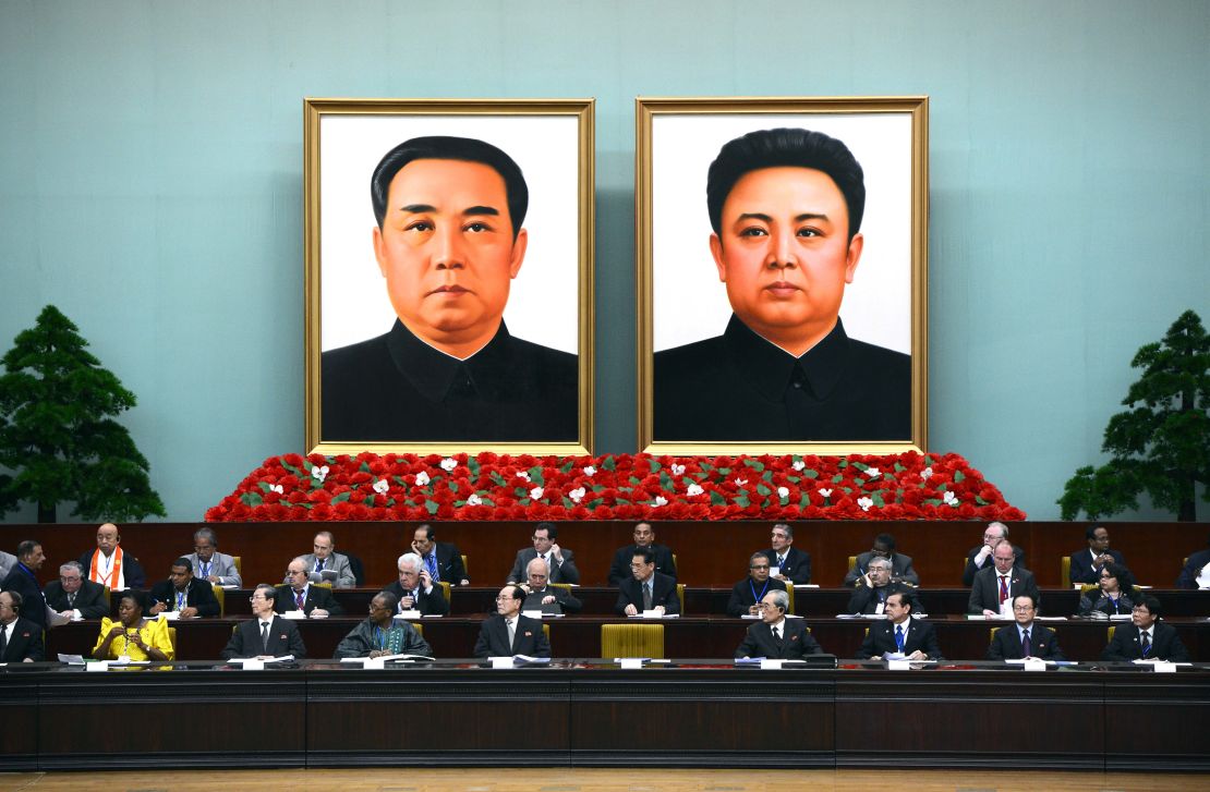 A portrait of late late Korean President Kim Il Sung (L) and his son, late leader Kim Jong Il hang of the wall as delegates take part in the World Congress of the Juche Idea in Pyongyang on April 12, 2012.
