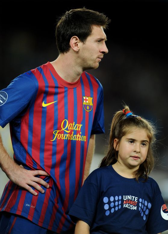 Three-time world player of the year Lionel Messi with a mascot wearing an anti-racism shirt ahead of Barcelona's UEFA Champions League match against Czech team Viktoria Plzen in October 2011.