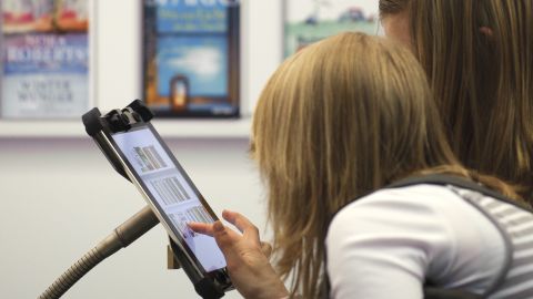 People looking at an e-book reader app on the Apple iPad.  