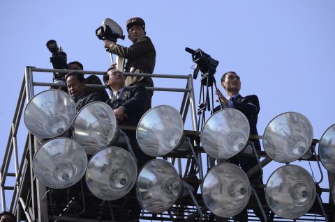 Members of the North Korean media look out from a viewing point during the parade.