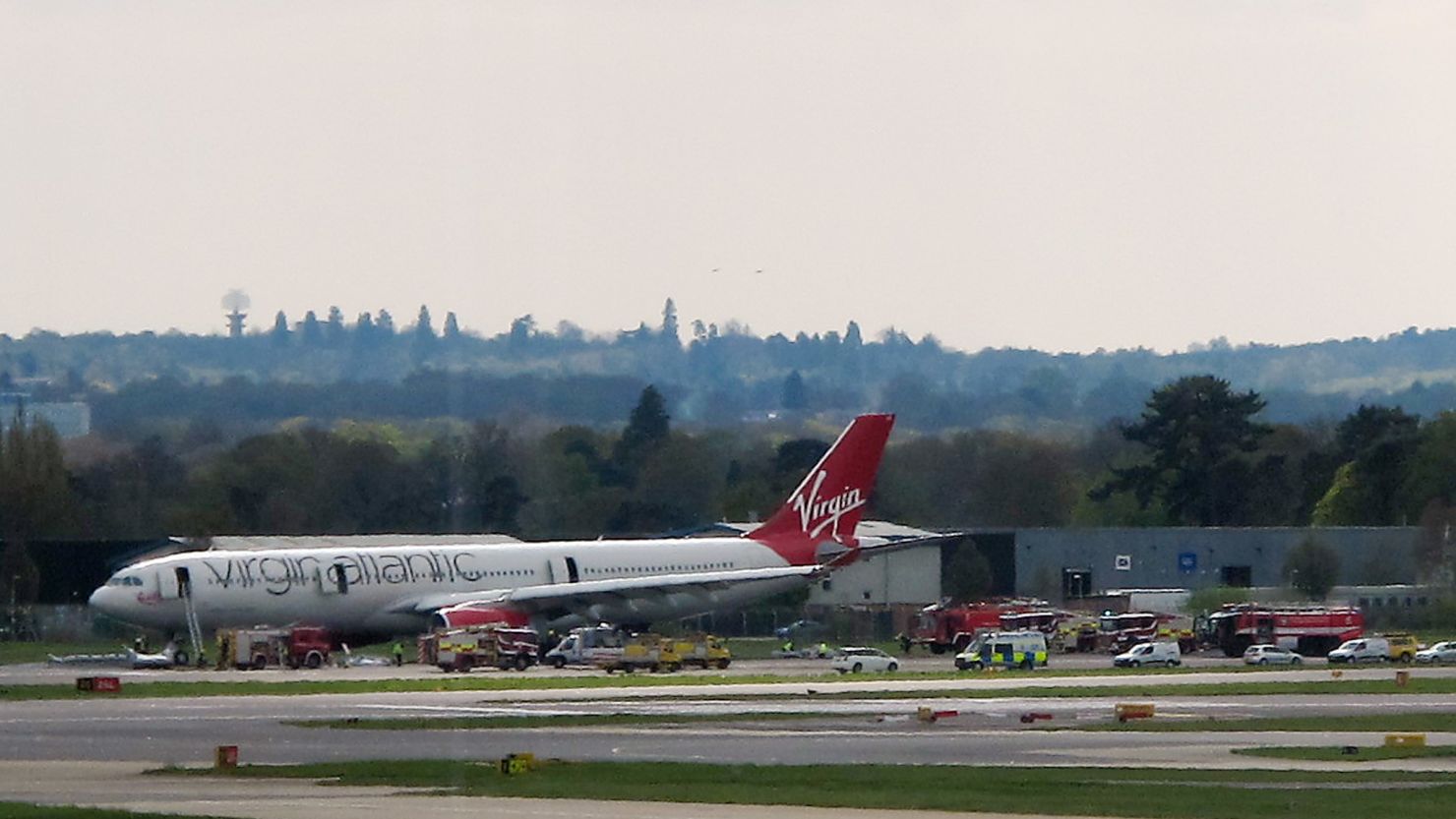 A Virgin Atlantic aircraft stands on the tarmac with emergency service vehicles in support after making an emergency landing at Gatwick Airport, London. 
