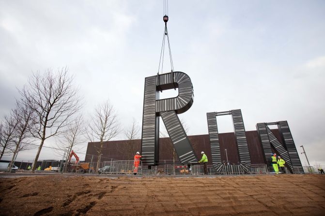 Workers carry out the installation of artist Monica Bonvicini's "RUN'"sculpture in the plaza of the London 2012 Handball Arena at the Olympic Park on January 12, 2012.