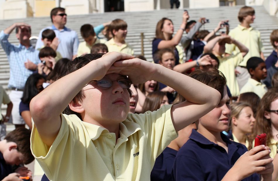 Schoolchildren on a tour watch as Discovery flies over the U.S. Capitol on Tuesday.