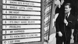 circa 1958:  American TV show host Dick Clark anounces the week's top ten popular songs during an episode of the television program, 'American Bandstand.'  (Photo by Hulton Archive/Getty Images)