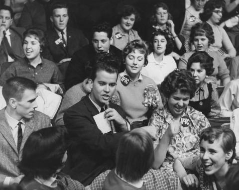 "American Bandstand" host Clark, pictured in 1958, surrounded by audience members.