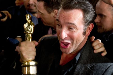 Jean Dujardin holds his Oscar for "The Artist," but will it offset for the loss of France's triple-A credit rating?