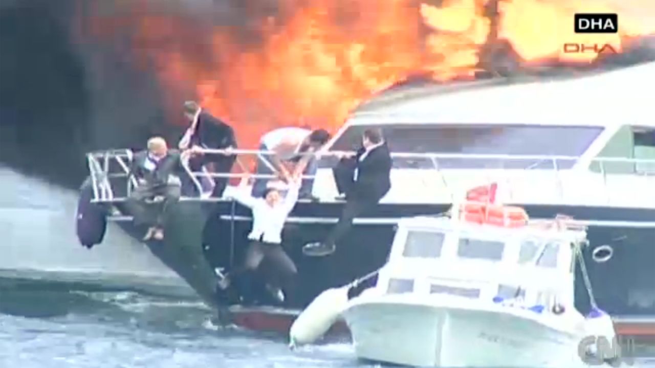 Well-dressed passengers escape a yacht that caught fire Wednesday in the Bosporus during a storm in Istanbul, Turkey.