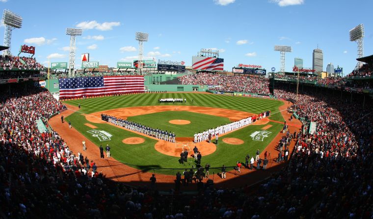 The Boston Red Sox and the Tampa Bay Rays line up for the national anthem during the home opener.