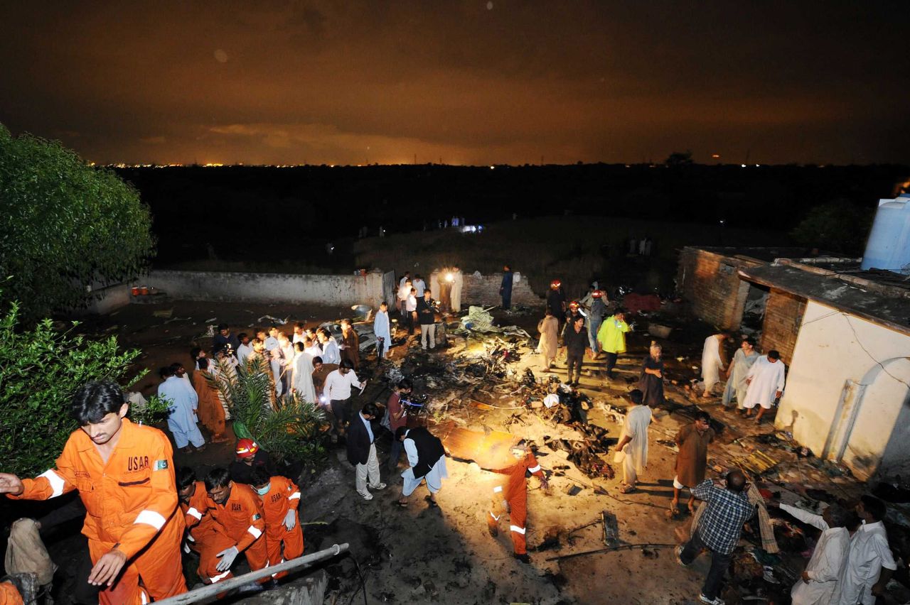 Pakistani rescue workers and local residents search the site of a plane crash in Rawalpindi on Friday, April 20. There is "no chance" of any survivors after a plane carrying up to 130 people crashed while trying to land in bad weather near Islamabad, police said.