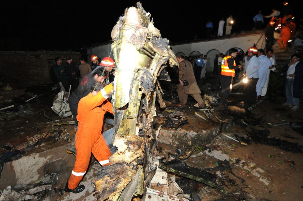 Rescue workers and local residents search the site of a plane crash in Rawalpindi, Pakistan, on Friday.