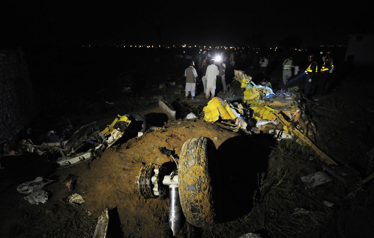 A plane wheel, center, lies amid debris at the scene of a plane crash as Pakistani rescue workers search for victims in the outskirts of Islamabad.