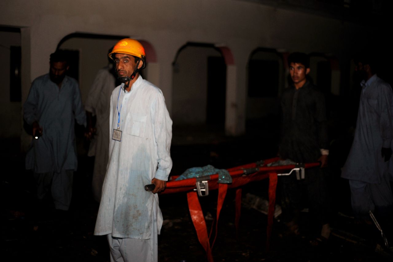 Pakistani rescue workers move a corpse in Hussain Abad.