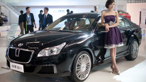 A model stands beside a 'B11' car by Chinese manufacturer Hawtai Motors at the Beijing car show.