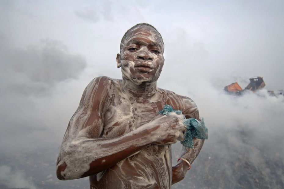  A man soaps himself on a dump after a day's work in Lagos. Olusosun Landfill Site is Nigeria's largest rubbish dump dealing with 2,400 metric tons of rubbish every day. A whole community lives on the dump, collecting scrap to trade for cash. 