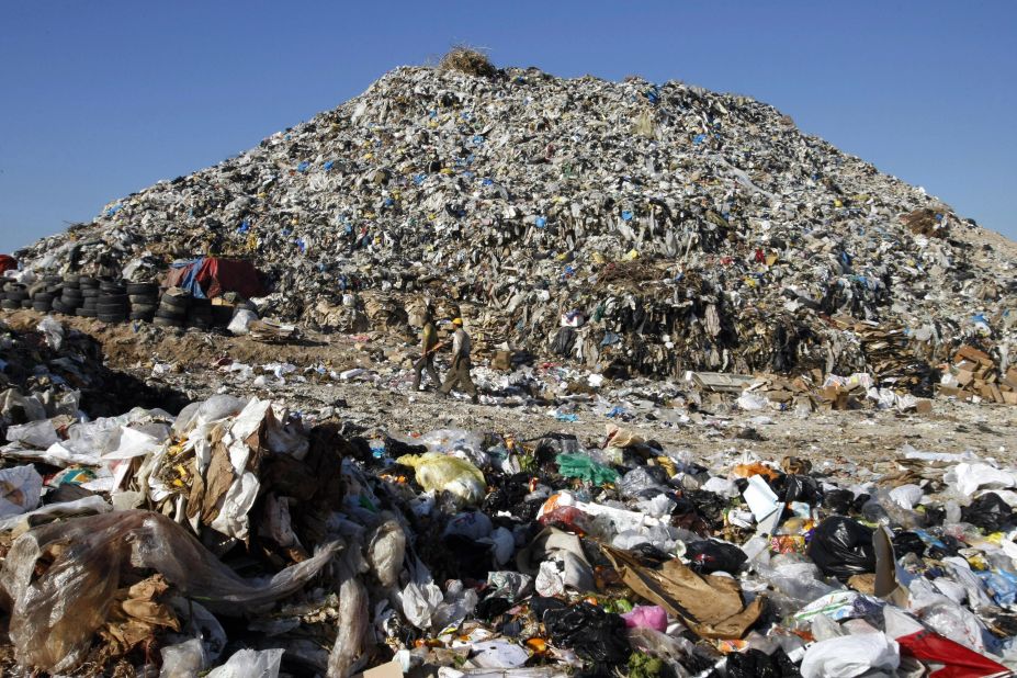 Men walk past a huge mound of garbage, piled up along the southern coastal Lebanese city of Sidon in 2008. 'Sidon's mountain' is an immense landfill that dumps its trash into the Mediterranean, polluting the coast of the ancient Phoenician port city. The dump is just a few metres away from the tourist sites of the southern city of Sidon -- its crusader sea castle, ancient vaulted souk and Phoenician temple.