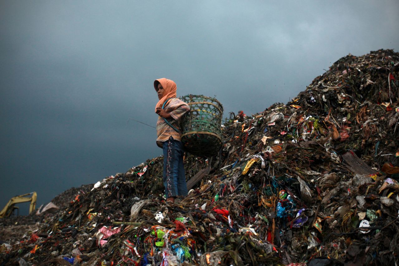 Eleven-year-old Nung, stands on the mountain of rubbish where she will collect plastic, at the Bantar Gebang landfill site, one of Jakarta's biggest dump sites. Around 6,000 metric tons of garbage is dumped daily at the landfill site, which will continue for the next 20 years, following the renewal of the site's contract in 2009.