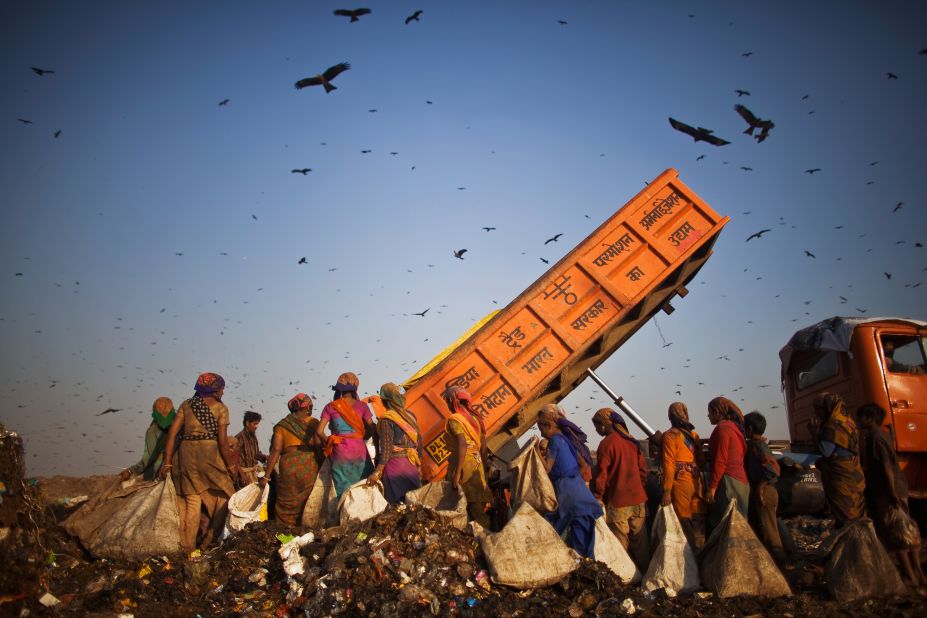 "Rag pickers" wait as a truck delivers garbage at the 70-acre Ghazipur Landfill site. They will sort through it picking out recyclable materials to sell. Delhi is estimated to have between 80,000 and 100,000 rag pickers who remove around 1,200-1,500 tons of trash from the municipal disposal chain each day. These activities, carried out in an ad-hoc way have unfavourable environmental, occupational health and community health implications.