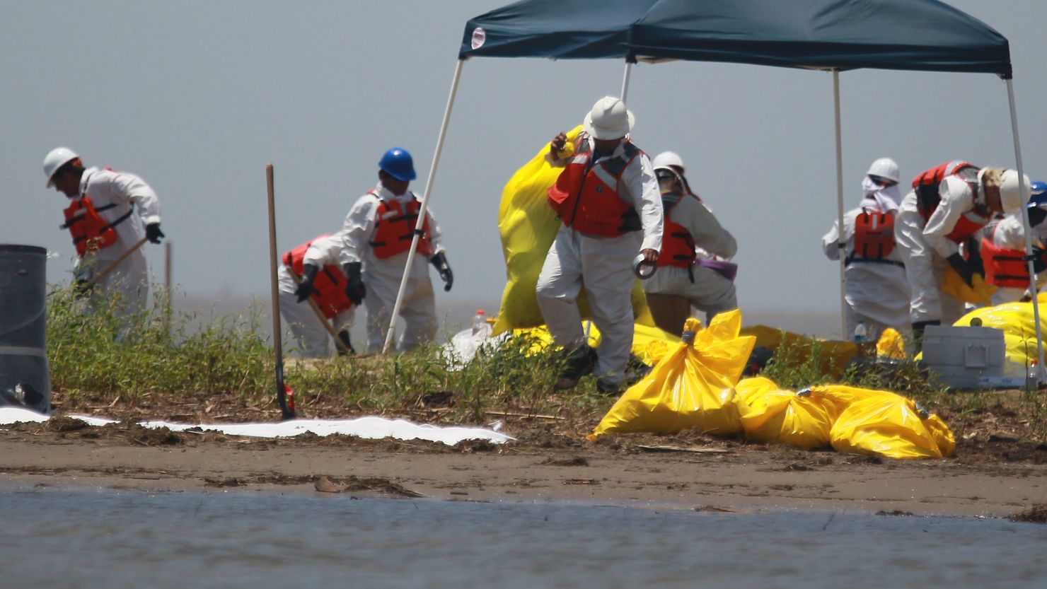 Workers clean a beach in South Pass, Louisiana, in May 2010 after the Deepwater Horizon explosion and spill.