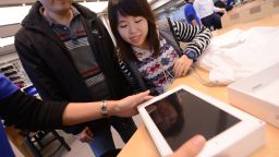 A woman smiles as her new iPad is presented to her at the Hong Kong Apple Store on March 16, 2012.